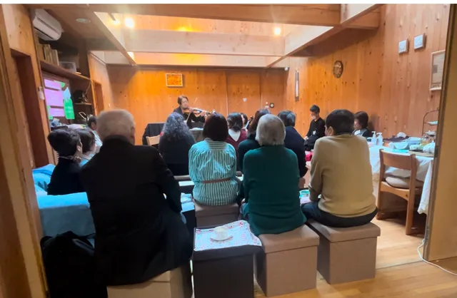 客席から演奏を聴く人々のイメージ